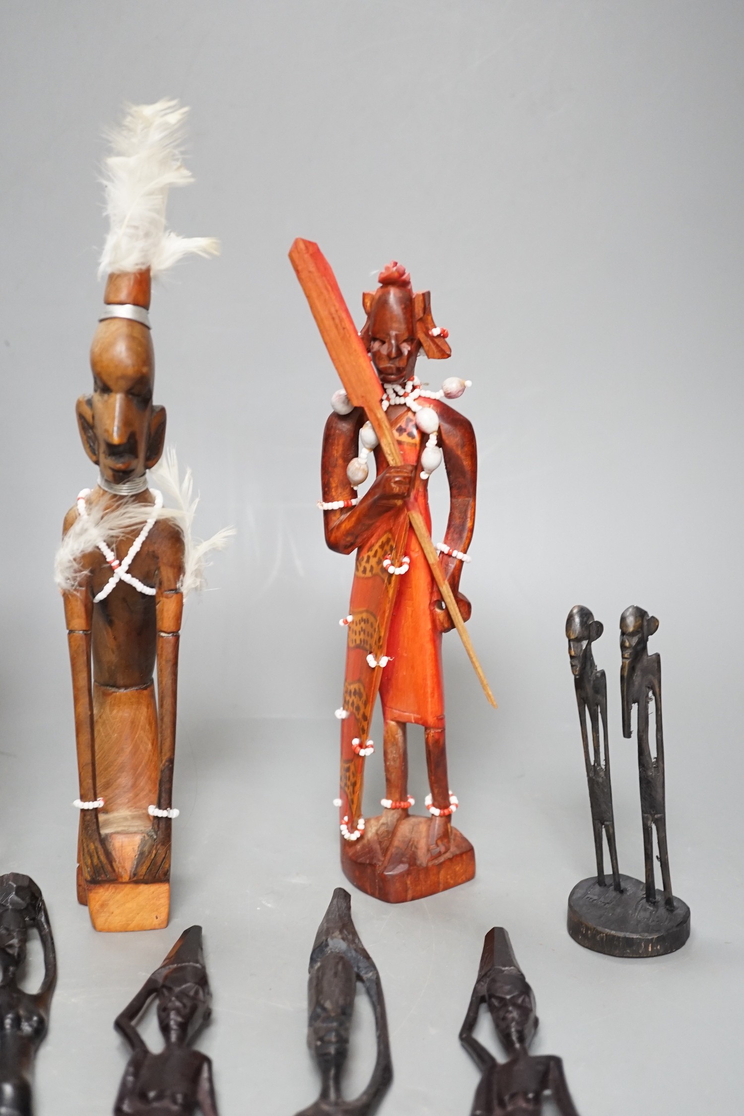 12 African carved wood stick figures, tallest 38cms high